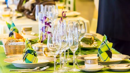 Party dinner table setting with tableware and silverware and glasses set and Candlestick and flower in restaurant.の写真素材