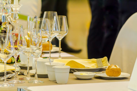 Party dinner table setting with tableware and silverware and glasses set and Candlestick and flower...
