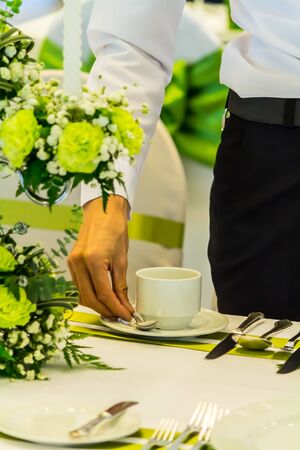 Waiter decorate and setting christmas party dinner table in restaurant.の写真素材