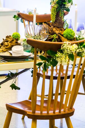Party dinner table setting with tableware and silverware and glasses set and Candlestick and flower in restaurant.の写真素材