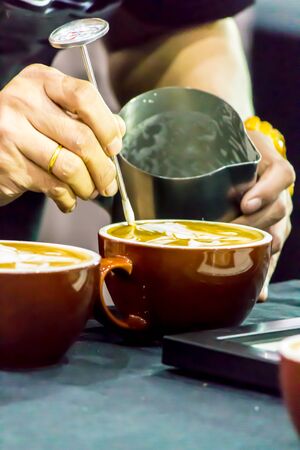Showcase Barista making Latte art coffee and Barista pouring fresh milk create art pattern on Latte coffe.の写真素材