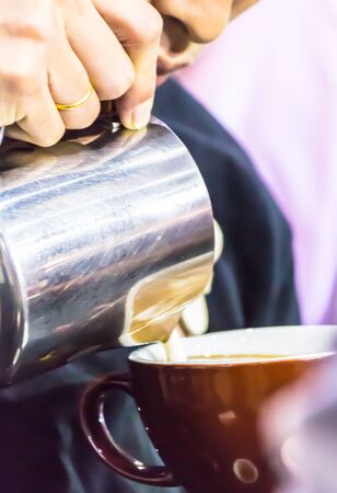 Showcase Barista making Latte art coffee and Barista pouring fresh milk create art pattern on Latte coffe.の写真素材