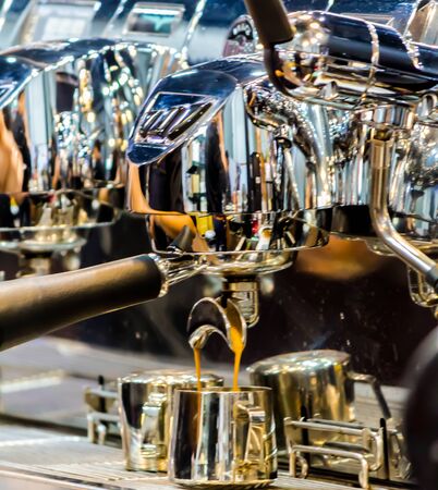 Showcase coffee maker by Espresso Machine pouring fresh coffee into cups at Local Coffee Shop.の写真素材