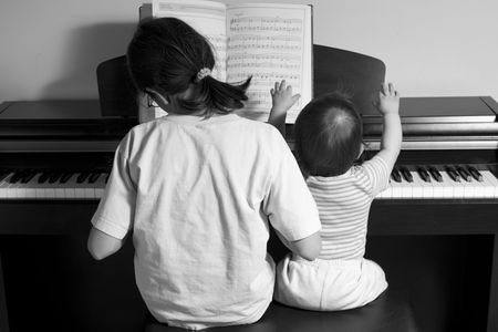 children playing piano (BW), back viewの写真素材