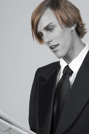 high society man in tuxedo fully absorbed in reading の写真素材