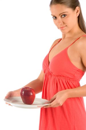 Female in red dress serving red apple on plateの写真素材