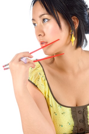 Chinese female in yellow dress with chopsticks の写真素材