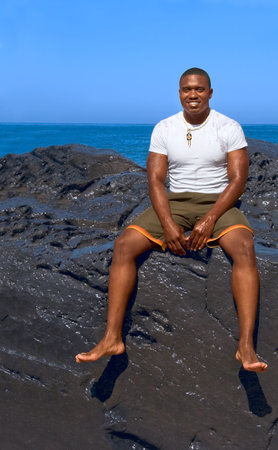 Portrait of African-American male sitting on cliffの写真素材