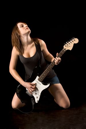 Teenager girl playing electric guitar in darkの写真素材