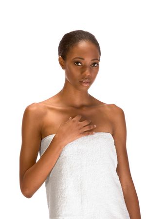 Beautiful young African-American woman with Slicked Back Hair wrapped in white bath towel preparing for saunaの写真素材