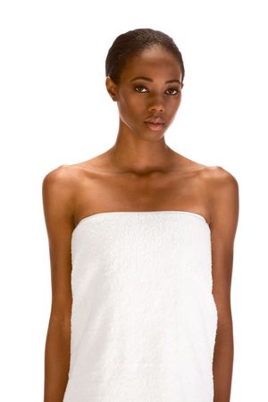 Beautiful young dark skinned woman with Slicked Back Hair wrapped in white bath towel preparing for saunaの写真素材