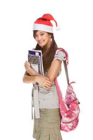 Asian schoolgirl wearing red Santa Claus hat with backpack holding Composition book, notebooks and penの写真素材