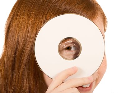 Young girl with red hair holding a blank white compact disk CD or DVD. Isolated on white. Your text or additional graphics can be added on CD/DVD cover according to your needs.の写真素材