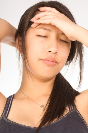 Young female squeezing her head apparently having headacheの写真素材