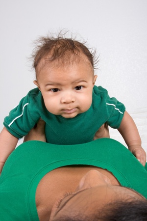 Biracial mom on bed with her multiethnic black infant son (baby is 3 months old)の写真素材