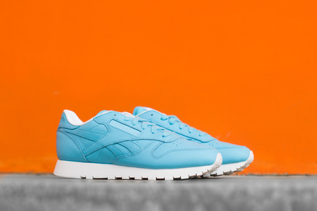 women's turquoise sneakers on orange backgroundの写真素材