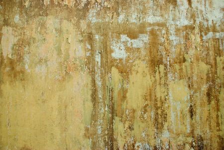 A dirty grunge wall with cracked, peeling paint and rusty texture.の写真素材