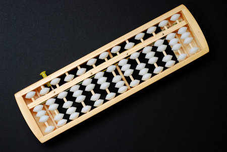 An abacus, a traditional calculating device on black background
