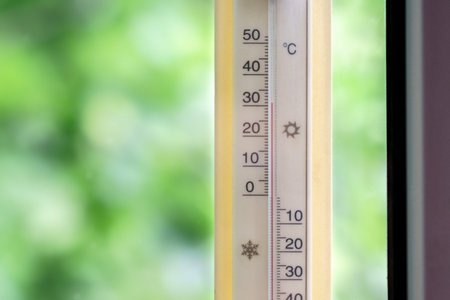The thermometer outside the window shows high hot temperature.の写真素材