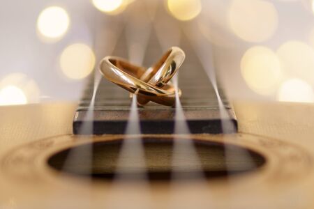 Wedding ring laying on ukulele guitar string.の写真素材
