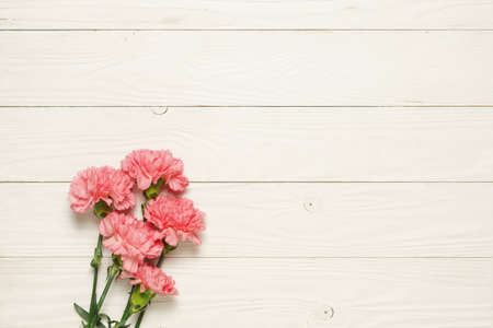 Bunch pink carnation flower bouquet on rustic wooden table.の写真素材
