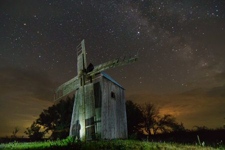 The ghost of the old mill. Old windmill at night with starry sky.の写真素材