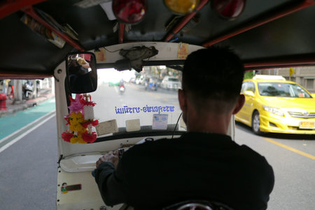 Tuktuk moving along a street in Bangkok.