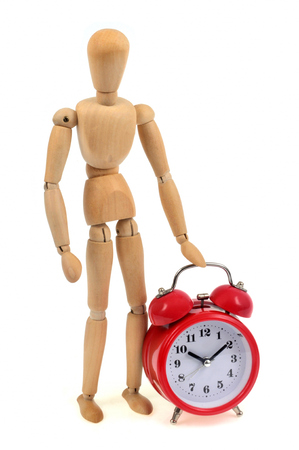 Wooden mannequin beside a morning wake upの写真素材