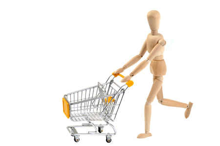 Wooden mannequin pushing a shopping cartの写真素材