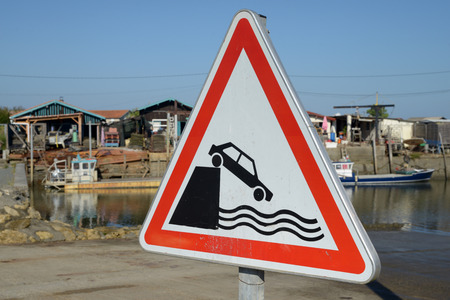 Sign indicating a risk of falling into the waterの写真素材