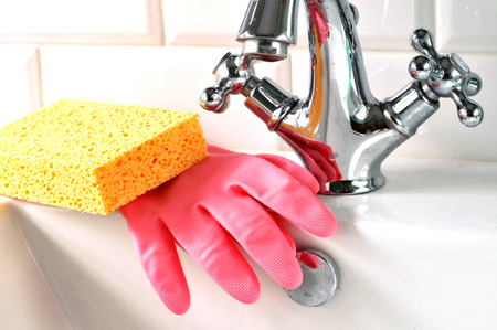 Gloves and sponge on a washbasinの写真素材