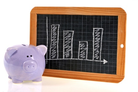 Piggy bank and graph on a slateの写真素材