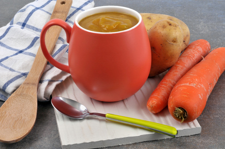 Cup of potato soup and carrotsの写真素材