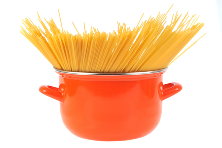 Raw spaghetti in a pot on a white backgroundの写真素材