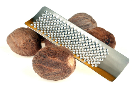 Nutmeg and grater on white backgroundの写真素材