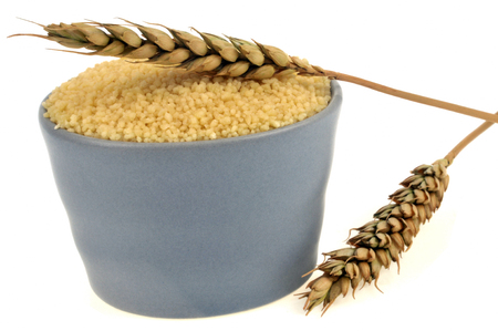 Ramequin of semolina and ears of wheat on a white backgroundの写真素材