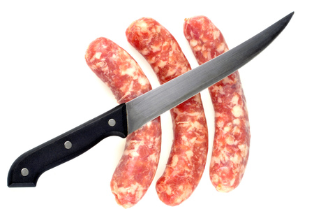 Knife with raw sausages on a white backgroundの写真素材