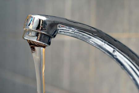 Flowing water from a faucetの写真素材