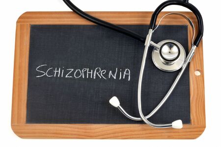 Schizophrenia written on a school slate with a stethoscopeの写真素材
