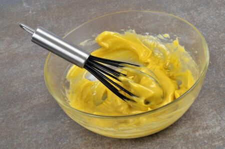 Salad bowl of homemade mayonnaise with a whisk on gray backgroundの写真素材