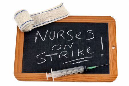 Nurses on strike writing on a school slateの写真素材