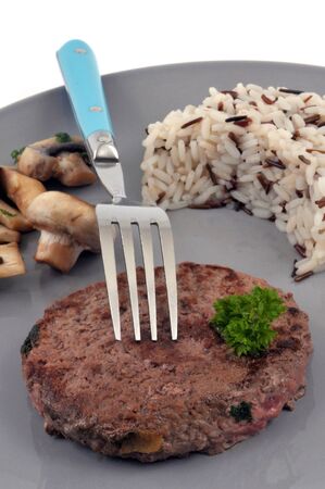 Chopped steak with rice and mushrooms served on a plateの写真素材