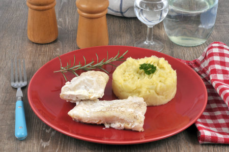 Cod and mashed potatoes in a plate close up