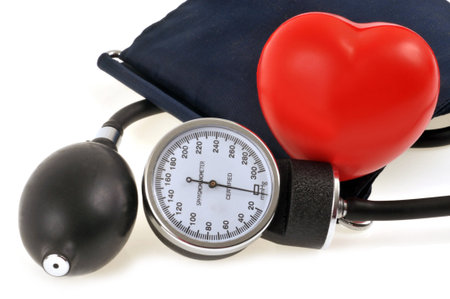 Heart and sphygmomanometer in close-up on white background