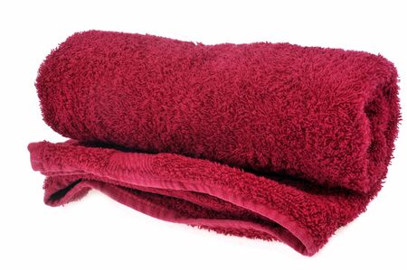 Red rolled up towel close up on white backgroundの写真素材