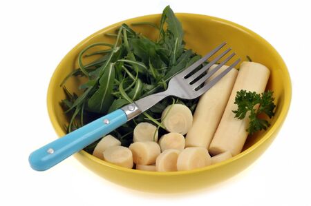 Hearts of palm and arugula in a plate close-up on white backgroundの写真素材