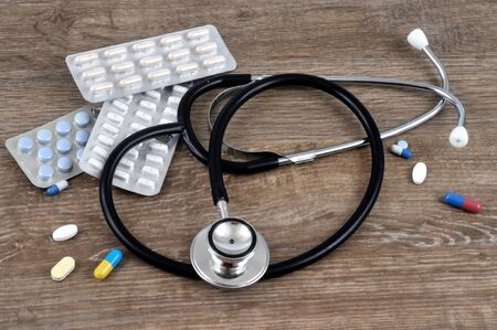 Stethoscope and drugs close up on a wooden backgroundの写真素材