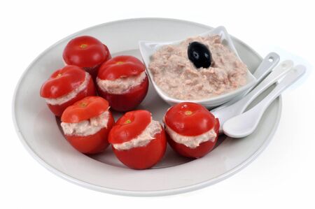 Amuse-bouche with cherry tomatoes stuffed with tuna rillettes served on a plate on white backgroundの写真素材