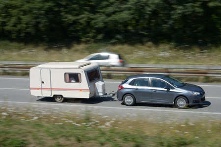 Car towing a caravan on an expresswayの写真素材