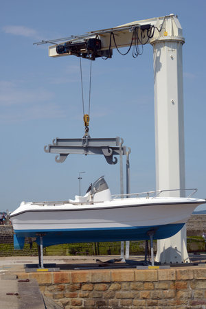 Launching a motor boat with a harbor craneの写真素材